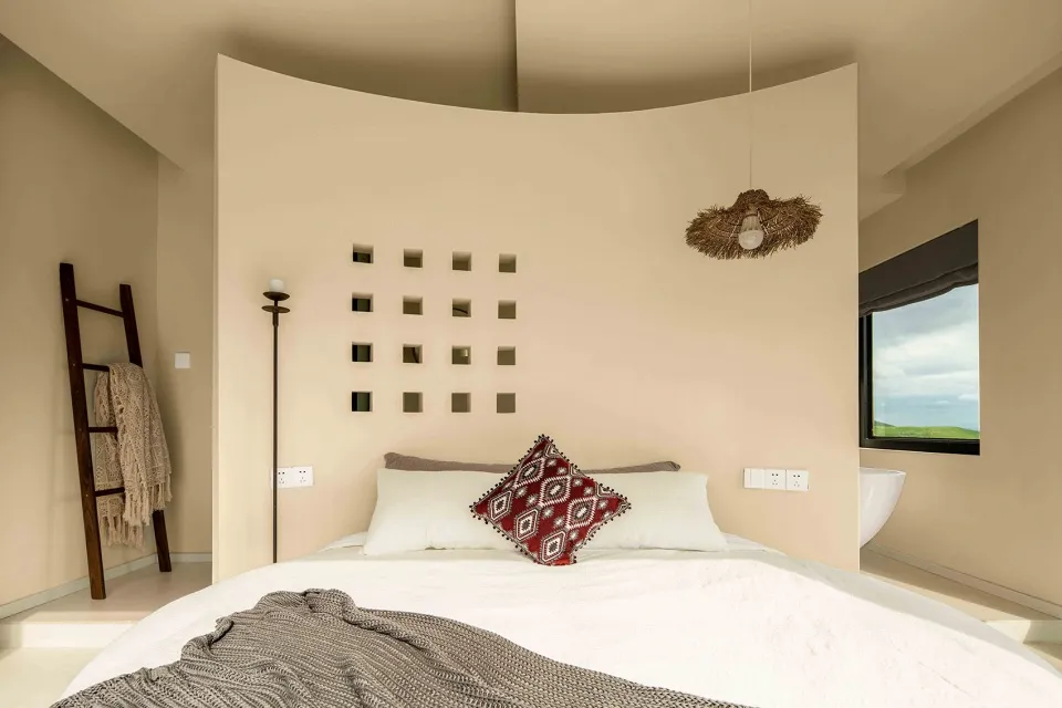 Bedroom with minimalist design, neutral colors, and neutral-colored bedding.