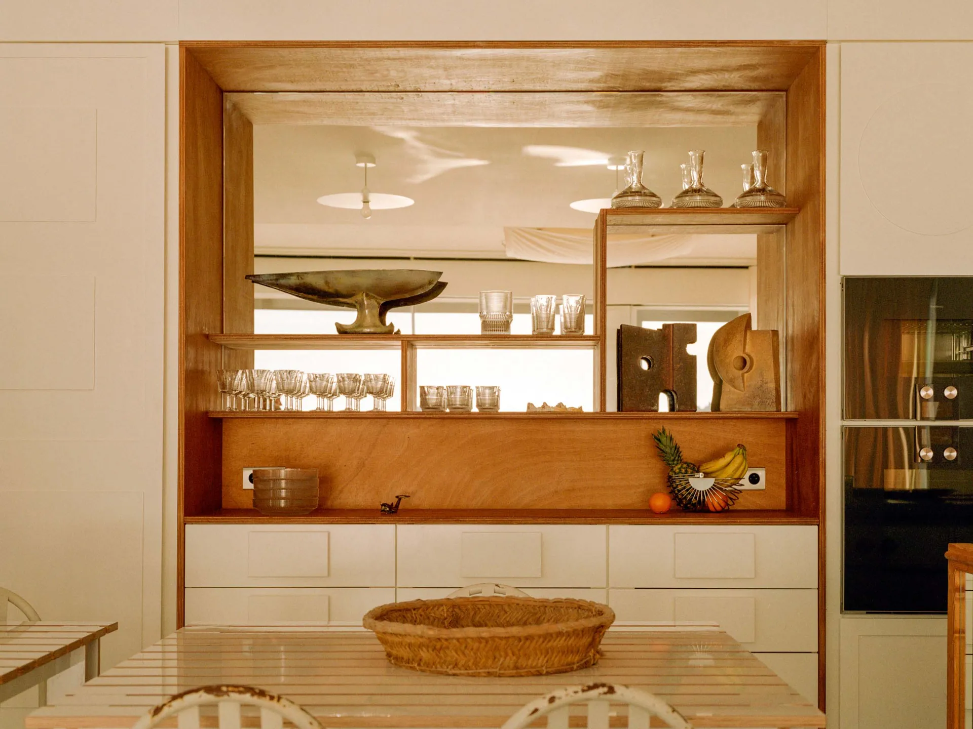 Modern kitchen featuring a wooden storage unit with glass shelves.