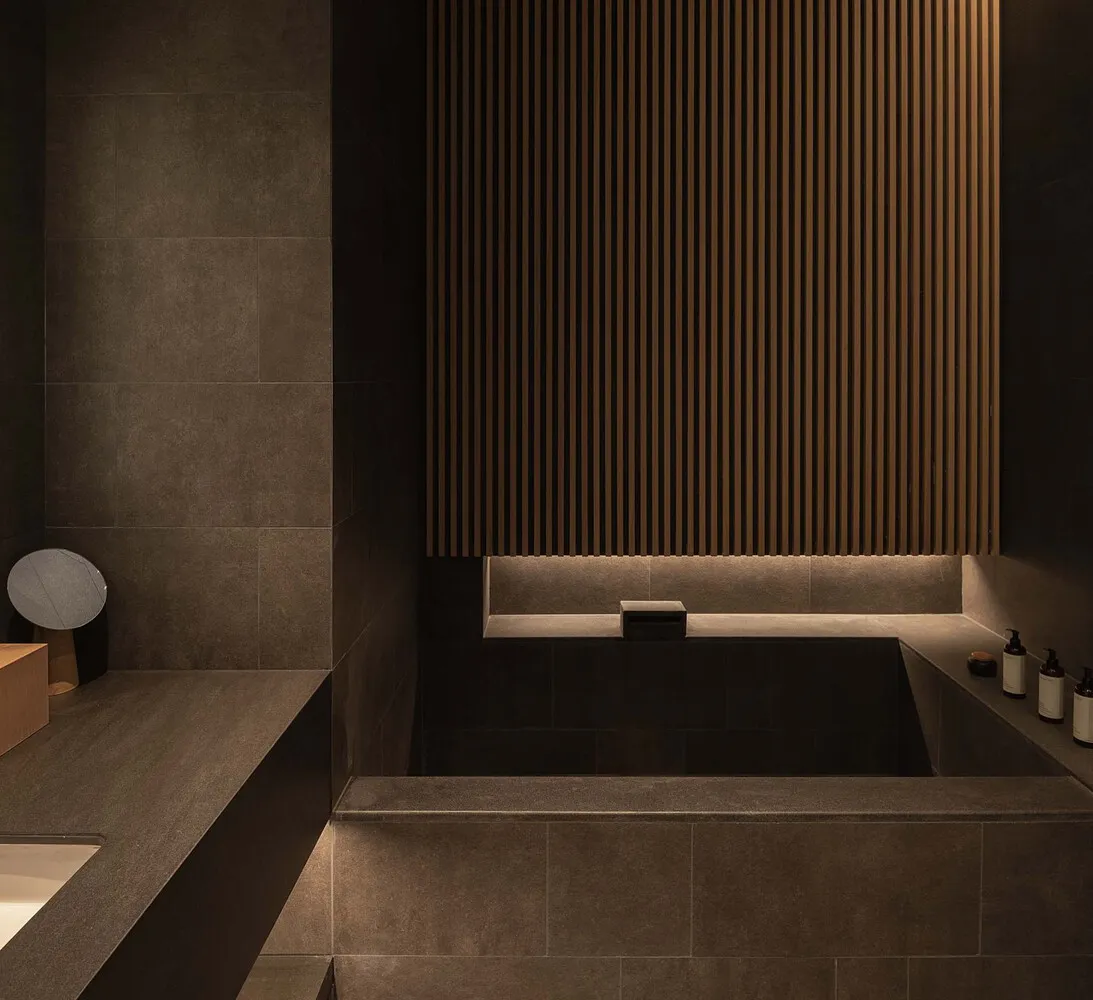 Modern bathroom with concrete tiles and wooden accents.
