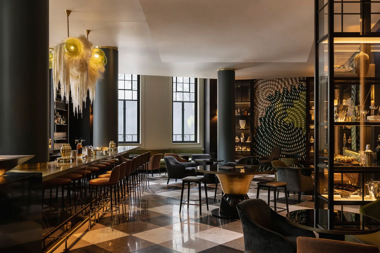 A modern hotel bar featuring metallic, glass, and marble elements.