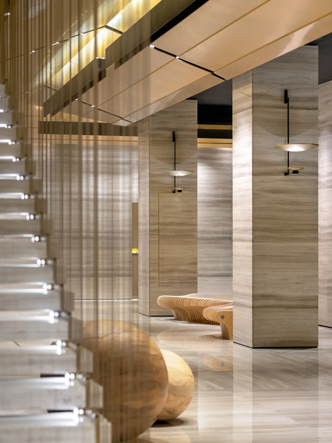 A minimalist modern lobby with marble walls and flooring.