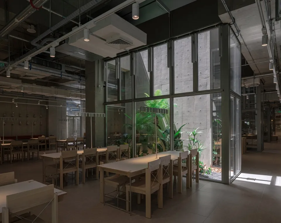 現代辦公室餐廳,融合混凝土、玻璃與木質元素。