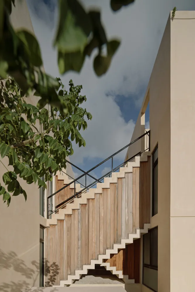 Modern, wooden staircase with black metal railing.