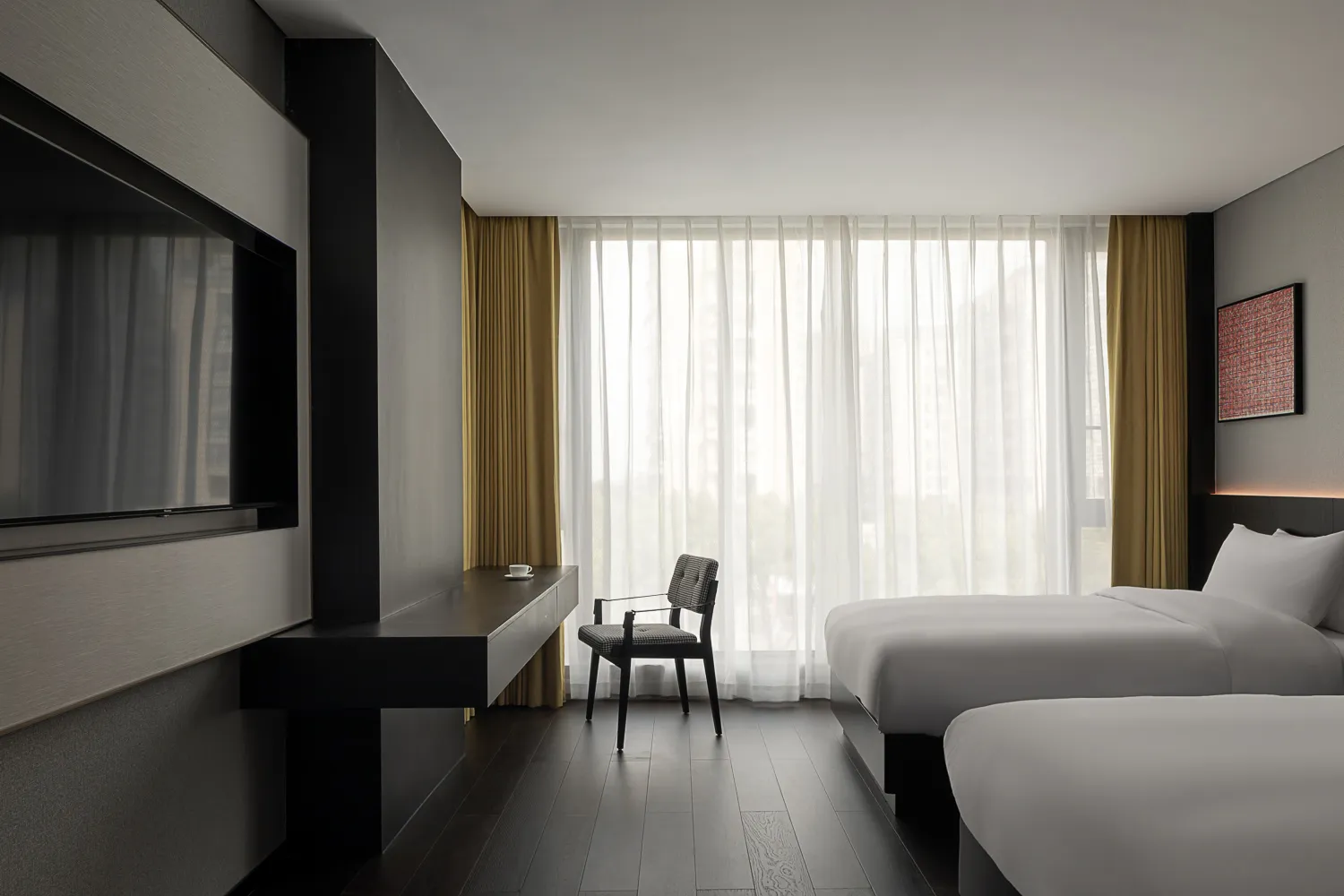 Minimalist hotel bedroom with two white beds, white linen, yellow curtains, and dark wood flooring.