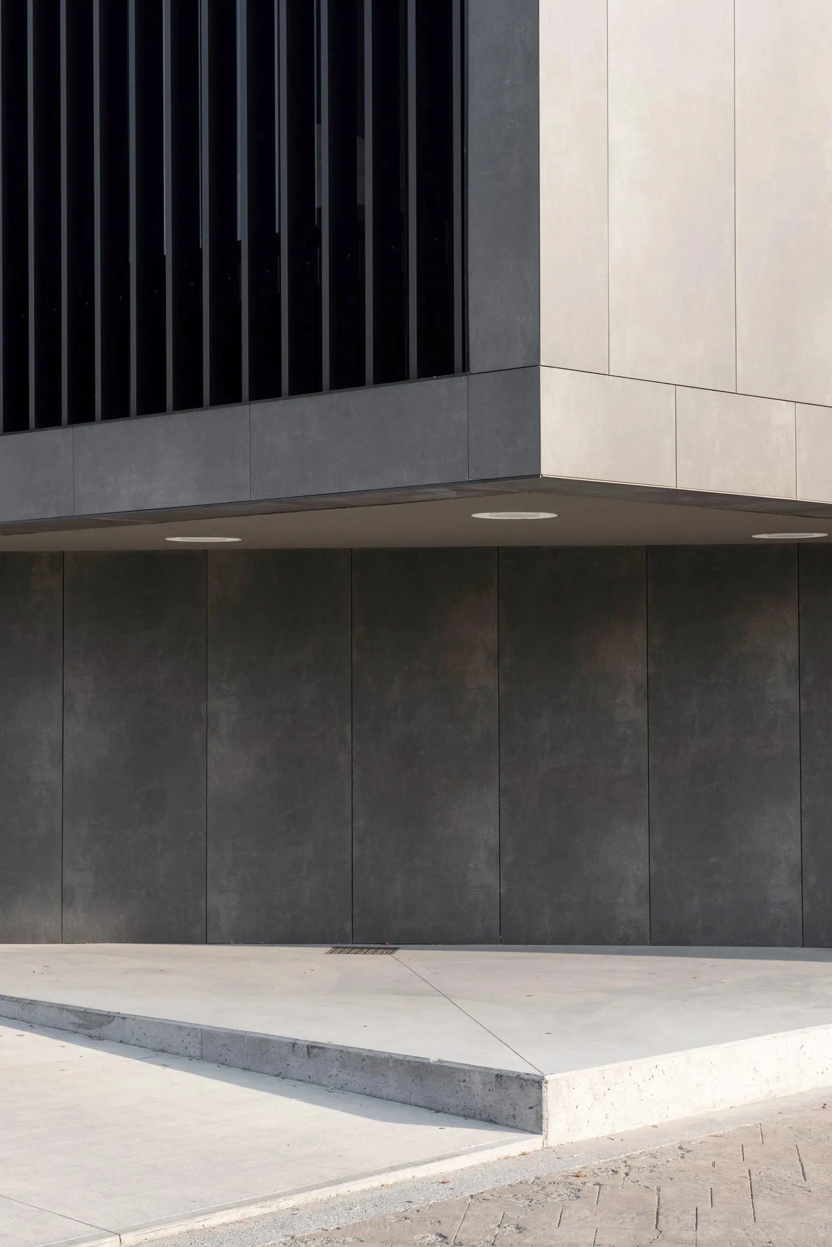 Detailed view of a modern building featuring concrete blocks and large windows.