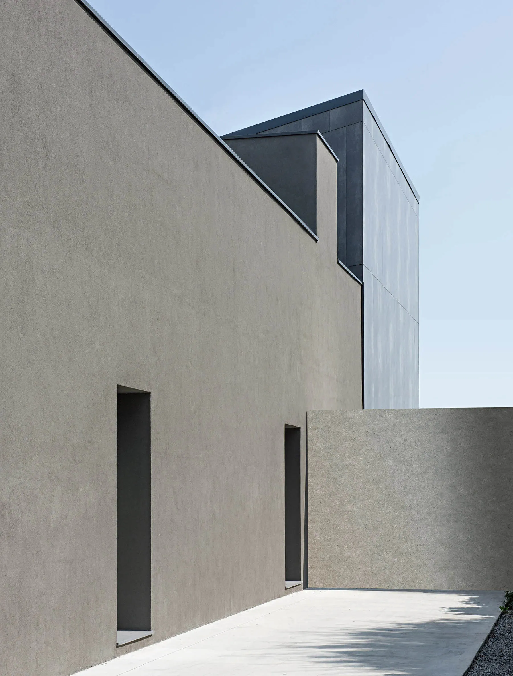 Minimalist modern concrete building exterior with clean lines and geometric shapes.