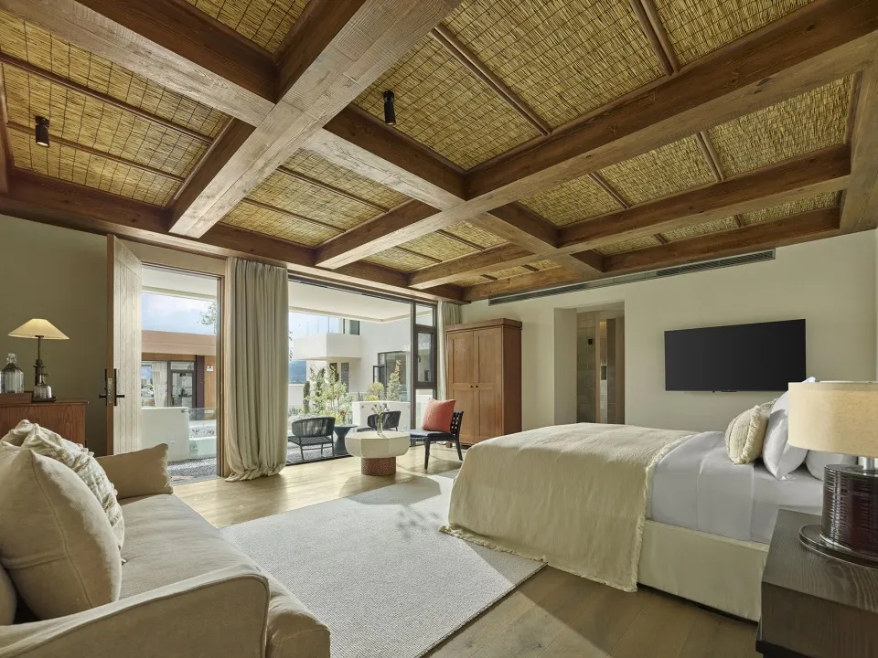 Modern residential bedroom featuring natural wood and fibers, with a comfortable bed, a cozy sofa, and a well-designed space.