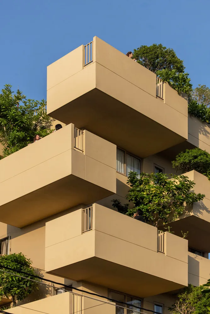 Modern residential building with concrete balconies and glass windows.