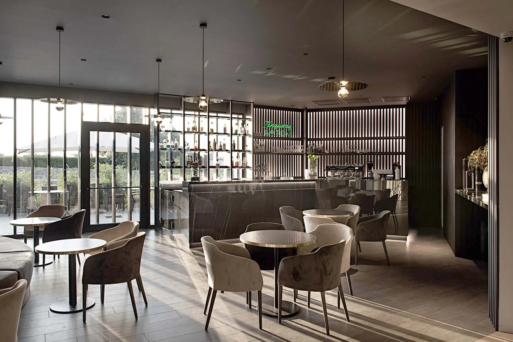 Modern restaurant bar area with concrete flooring and minimalist decor.