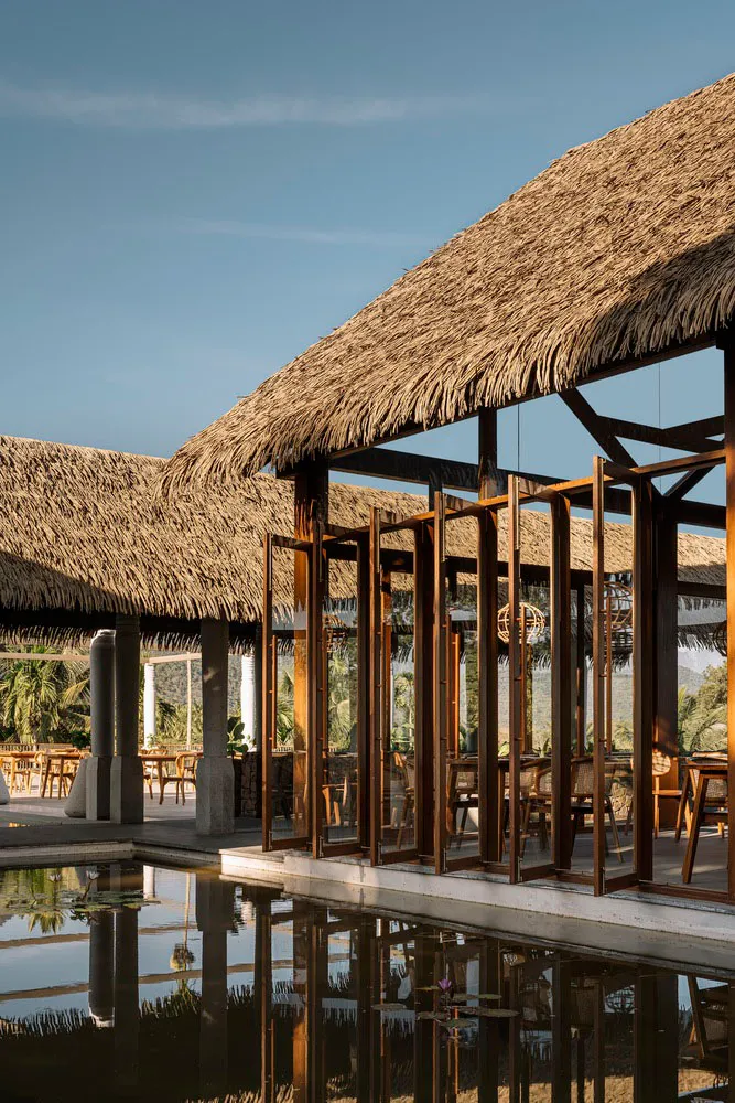 Modern architectural design featuring a thatched roof and open wooden frame.