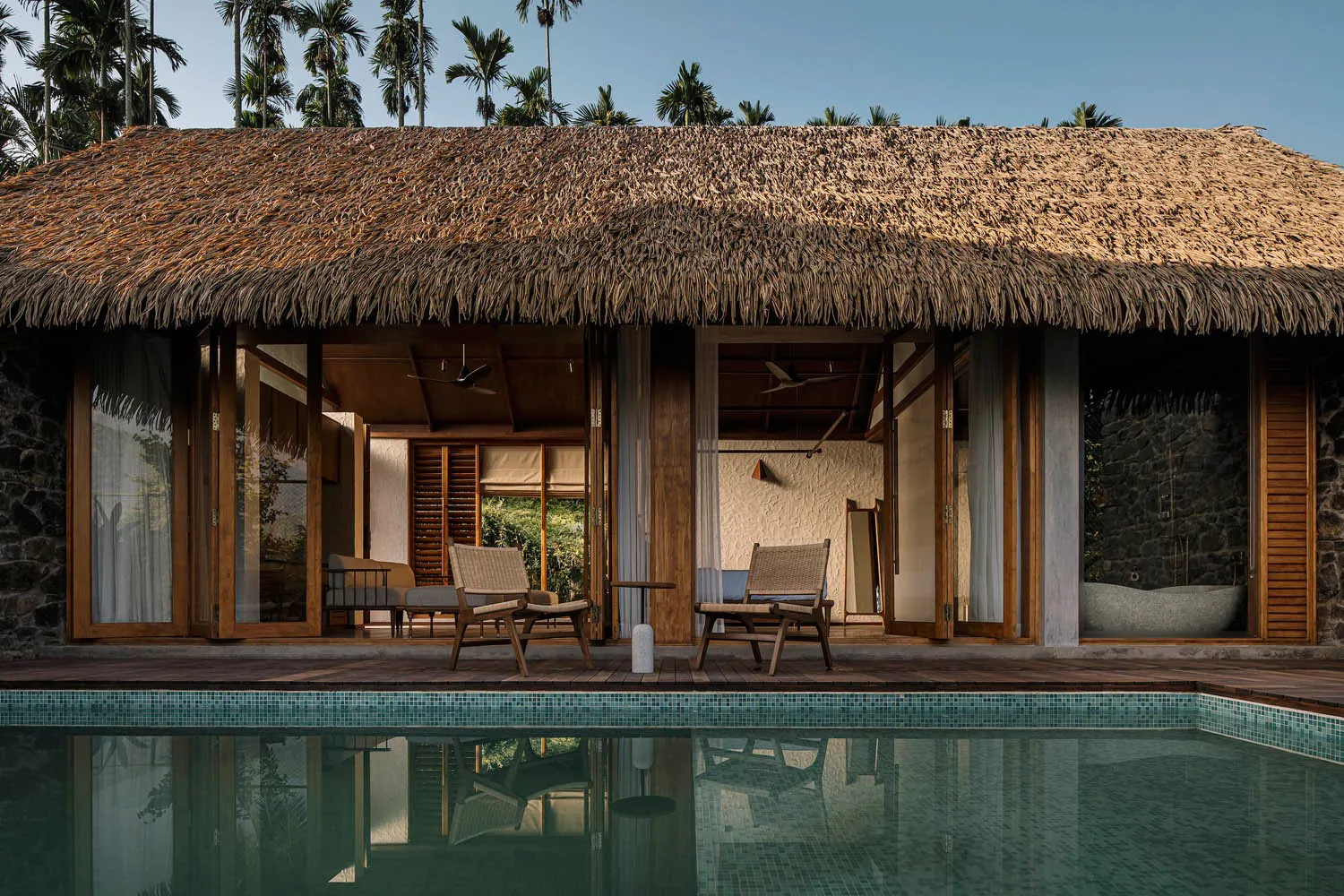 Thatched cottage with stone walls and glass doors