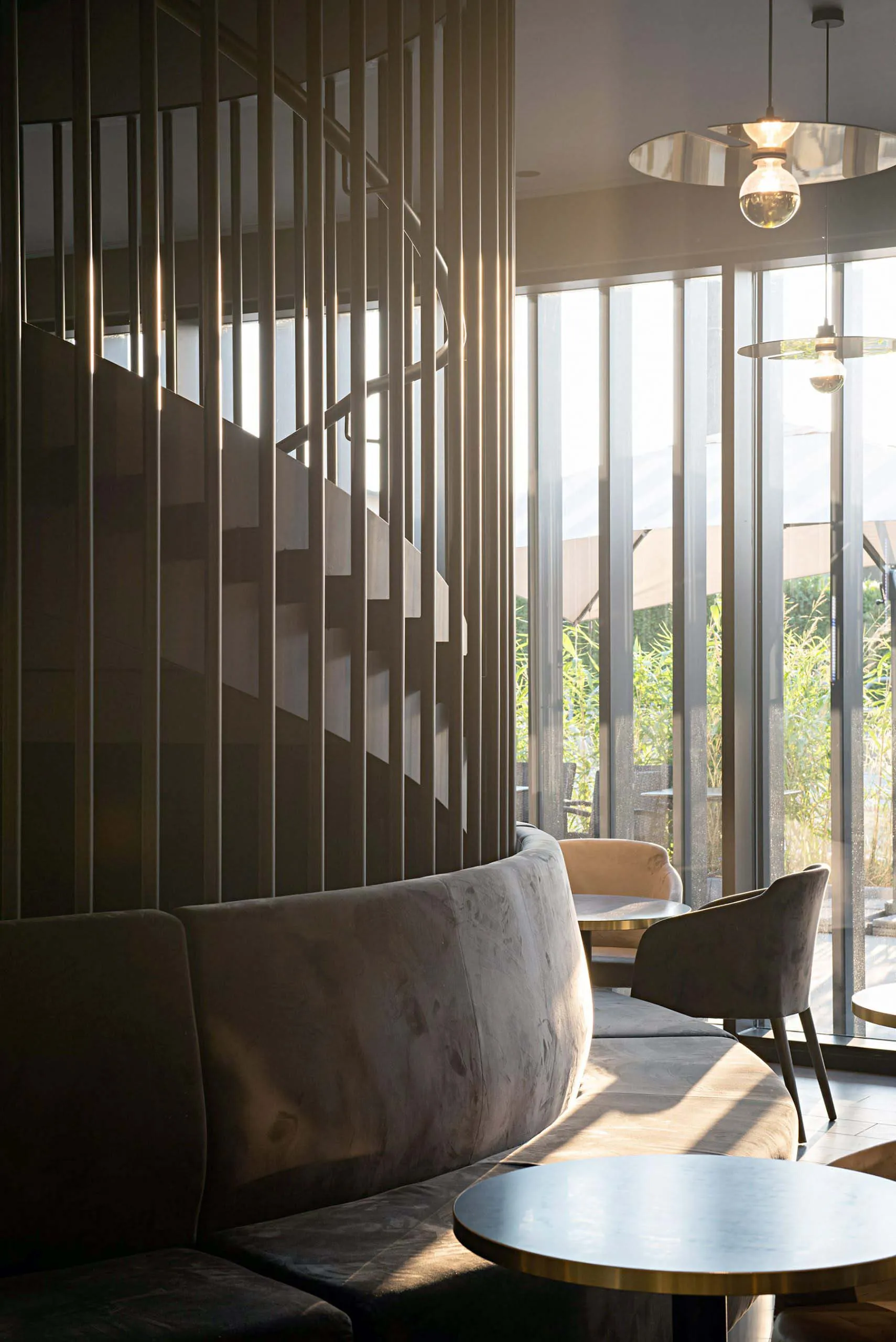 A cozy cafe bar with velvet seating and glass windows