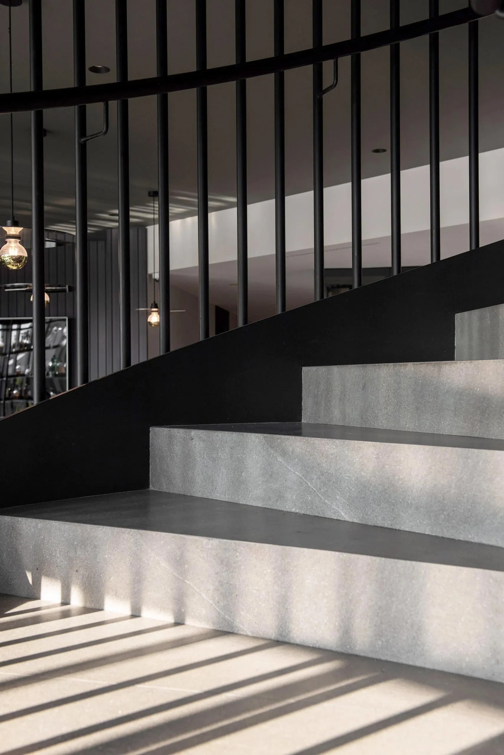 Concrete stairs with a minimalist design and black metal railing.