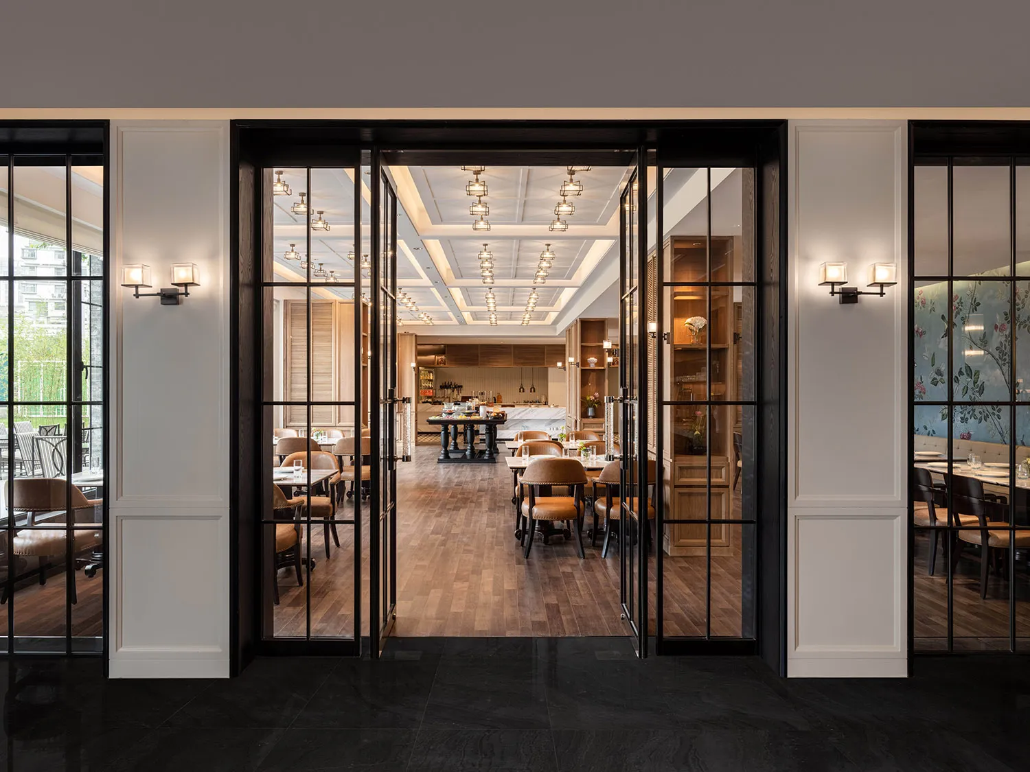 Industrial-style cafe interior with wooden floors, glass walls, and metal furniture.