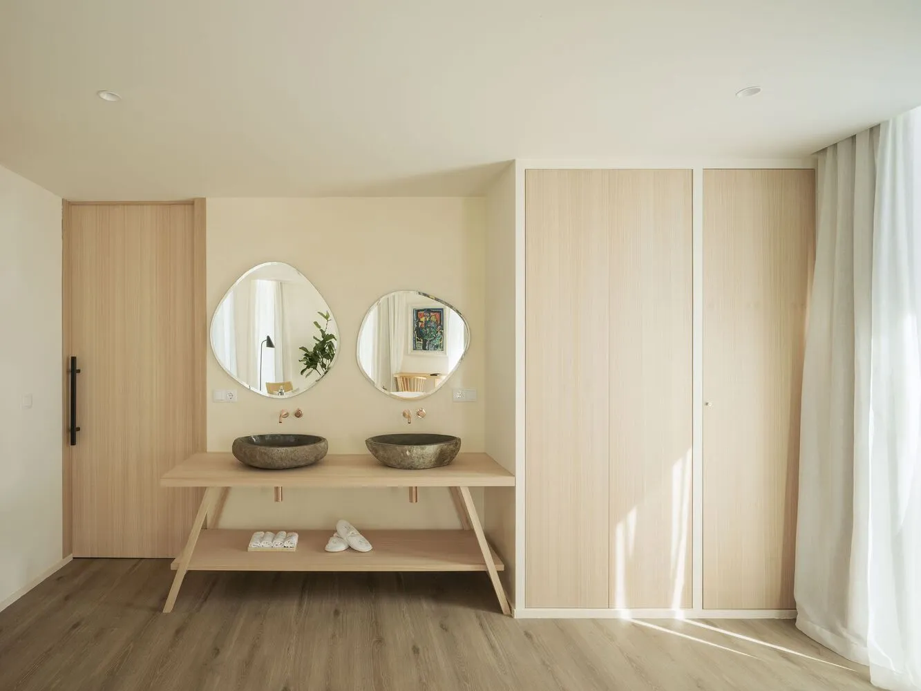 Minimalist kitchen with pristine white appliances, wood laminate flooring, and a sleek, modern design.