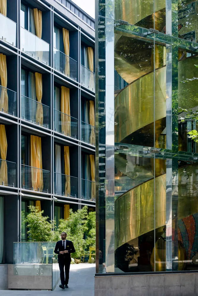 A modern building with glass, metal, and yellow curtains.