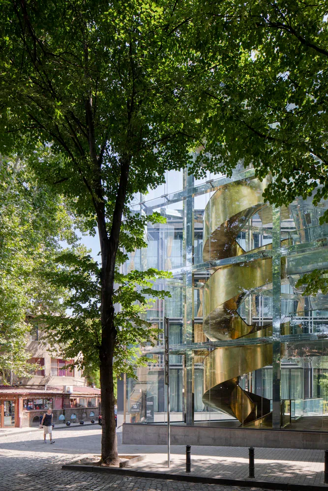 Modern building with glass facade and spiral staircase.