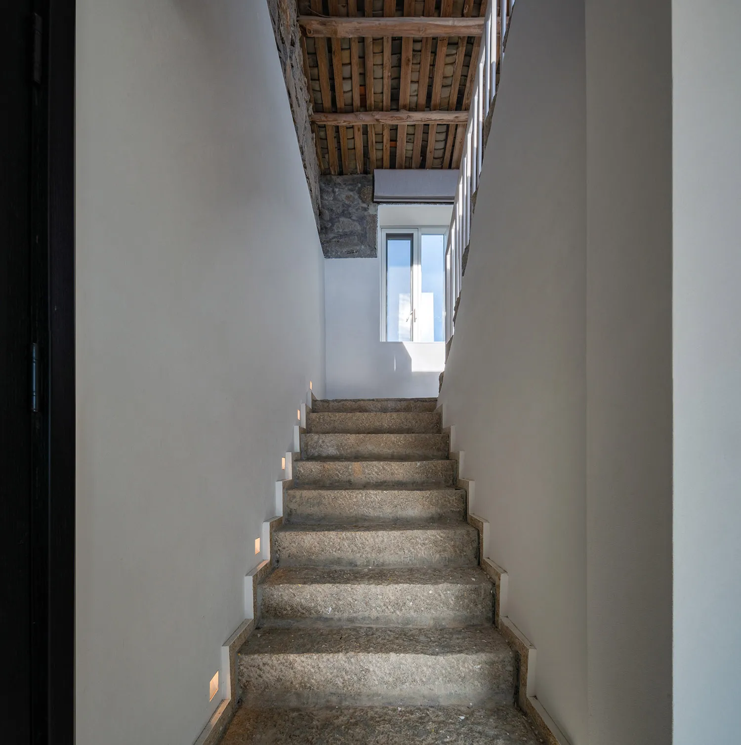 Concrete staircase with walls and wooden beams in an industrial design setting.