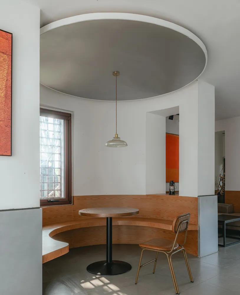 Industrial-themed restaurant seating area with wooden benches and a round table.