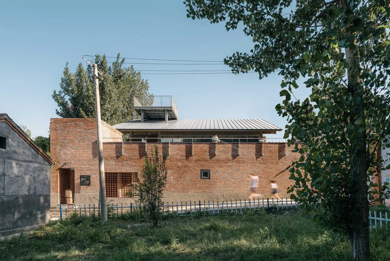 Modern building with brick exterior and metal roof.