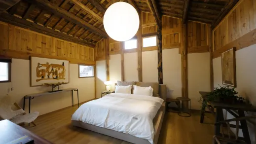 A spacious residential interior with exposed wood beams and industrial features.