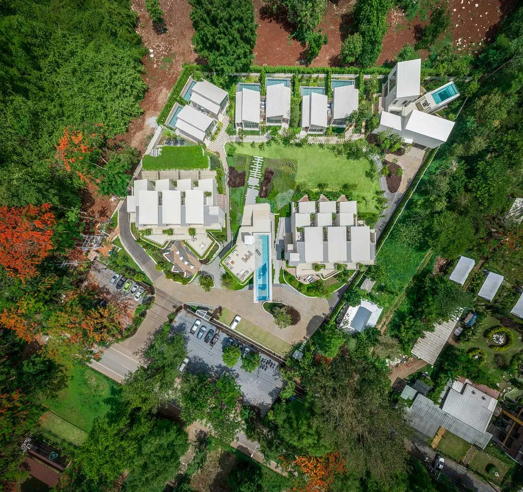 A modern residential community depicted in a rendered view showcasing contemporary architecture and greenery.