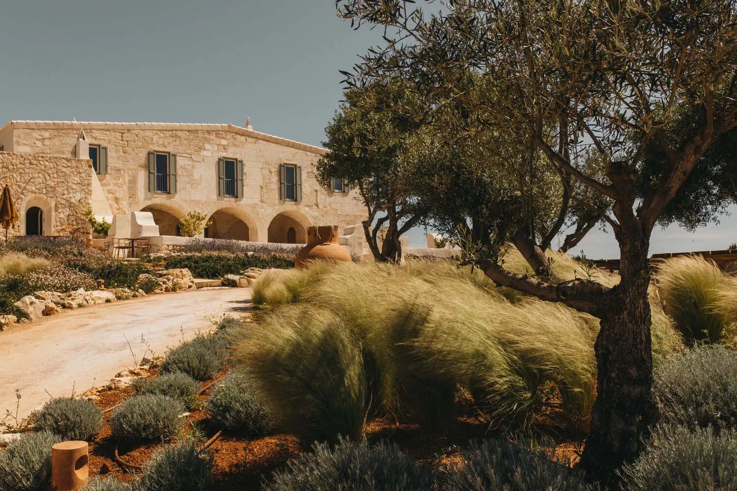A stone-walled residence with a courtyard and outdoor seating area.