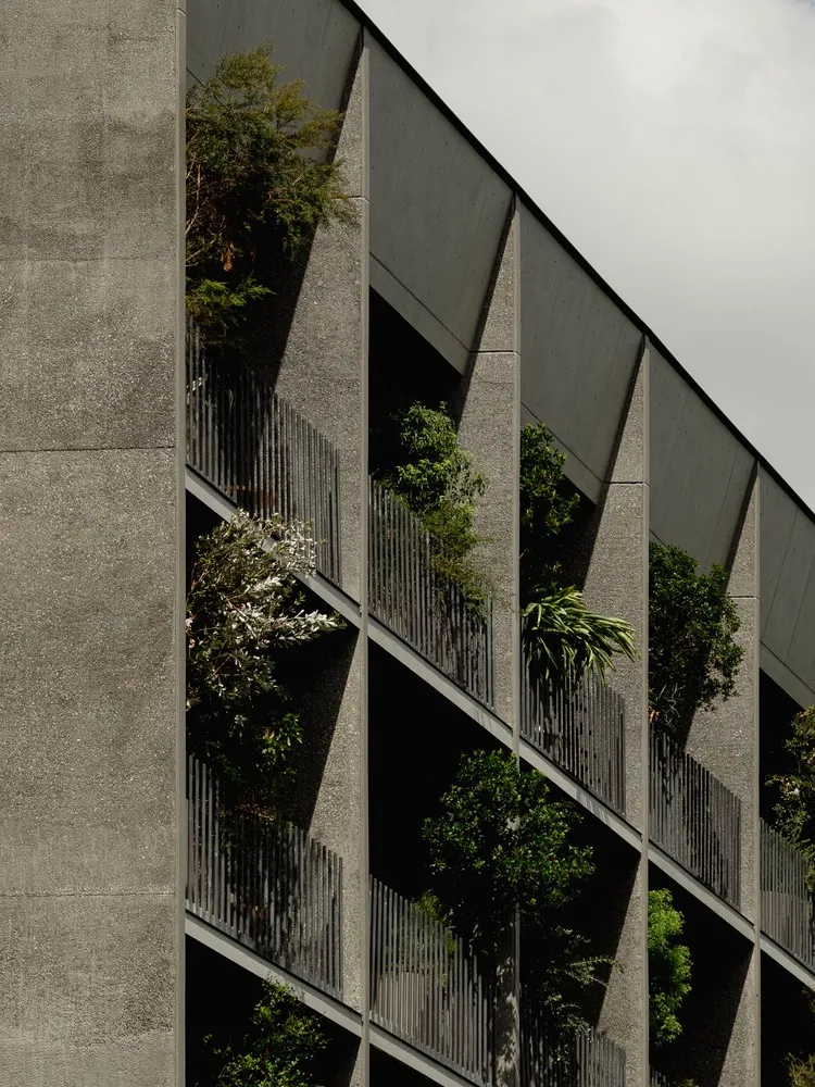 Sustainable building exterior with green roofs and gardens integrated into the design.