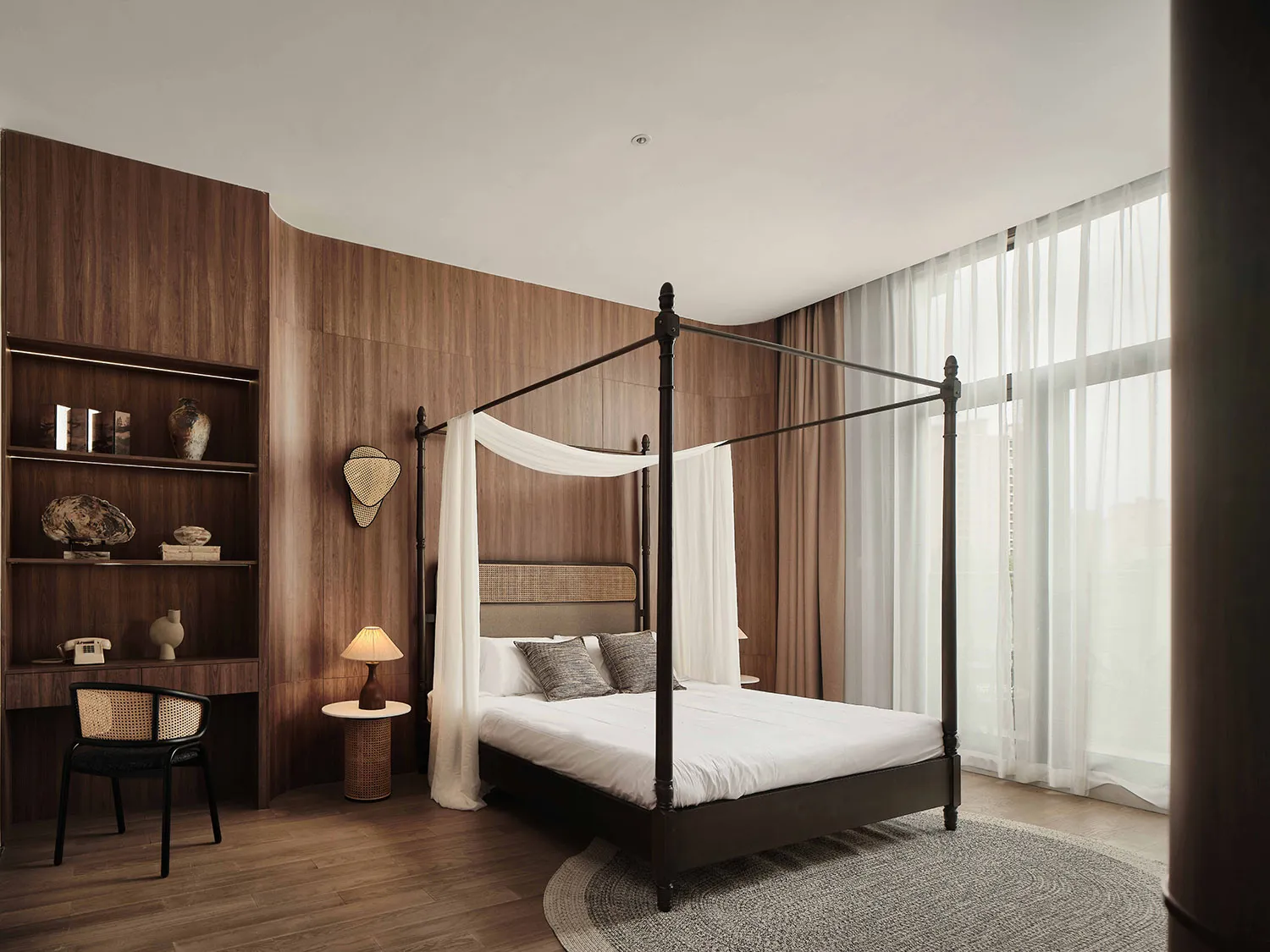 A minimalist bedroom with wooden walls, a wooden bed frame, and white cotton bedding.