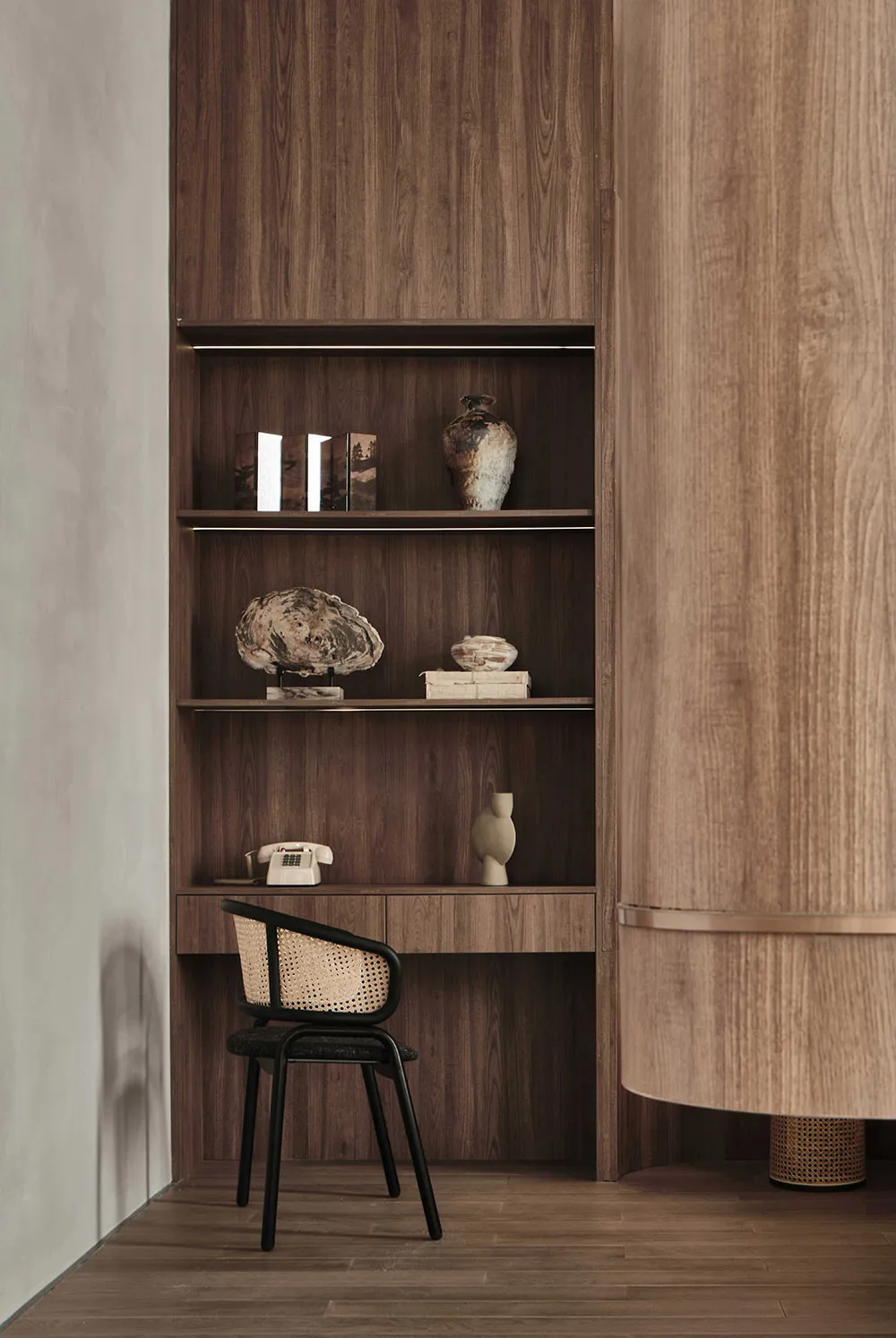 Minimalist home office with wooden furniture and shelves.