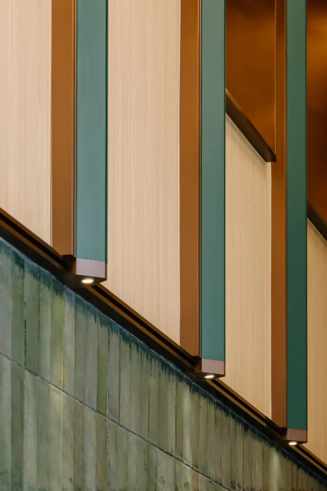 A modern staircase with metal railings and green and brown tiles