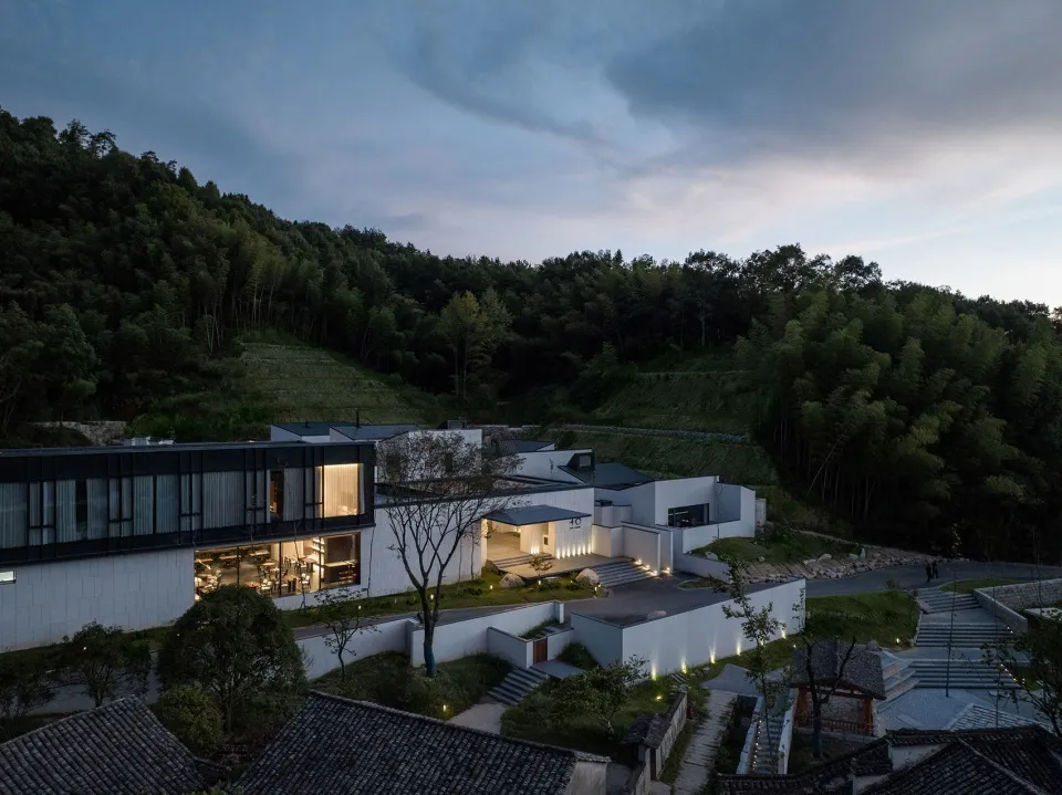 A modern house featuring concrete, glass, and stone exterior materials.