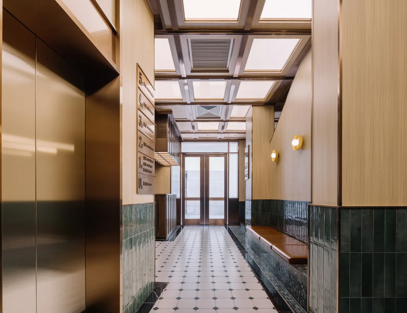 Modern interior design featuring a metal corridor with glass doors and wooden benches.