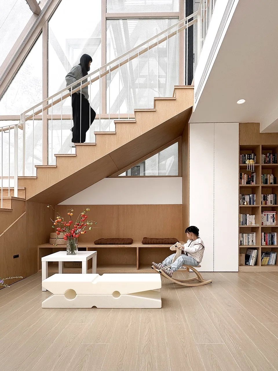 現代客廳採用淺木地板、極簡家具與大型書櫃。