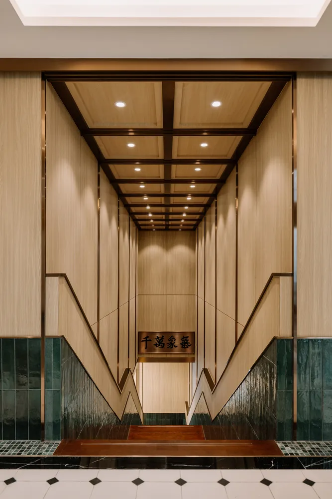 An elegant, tall staircase with wooden panels and marble flooring leading upwards.