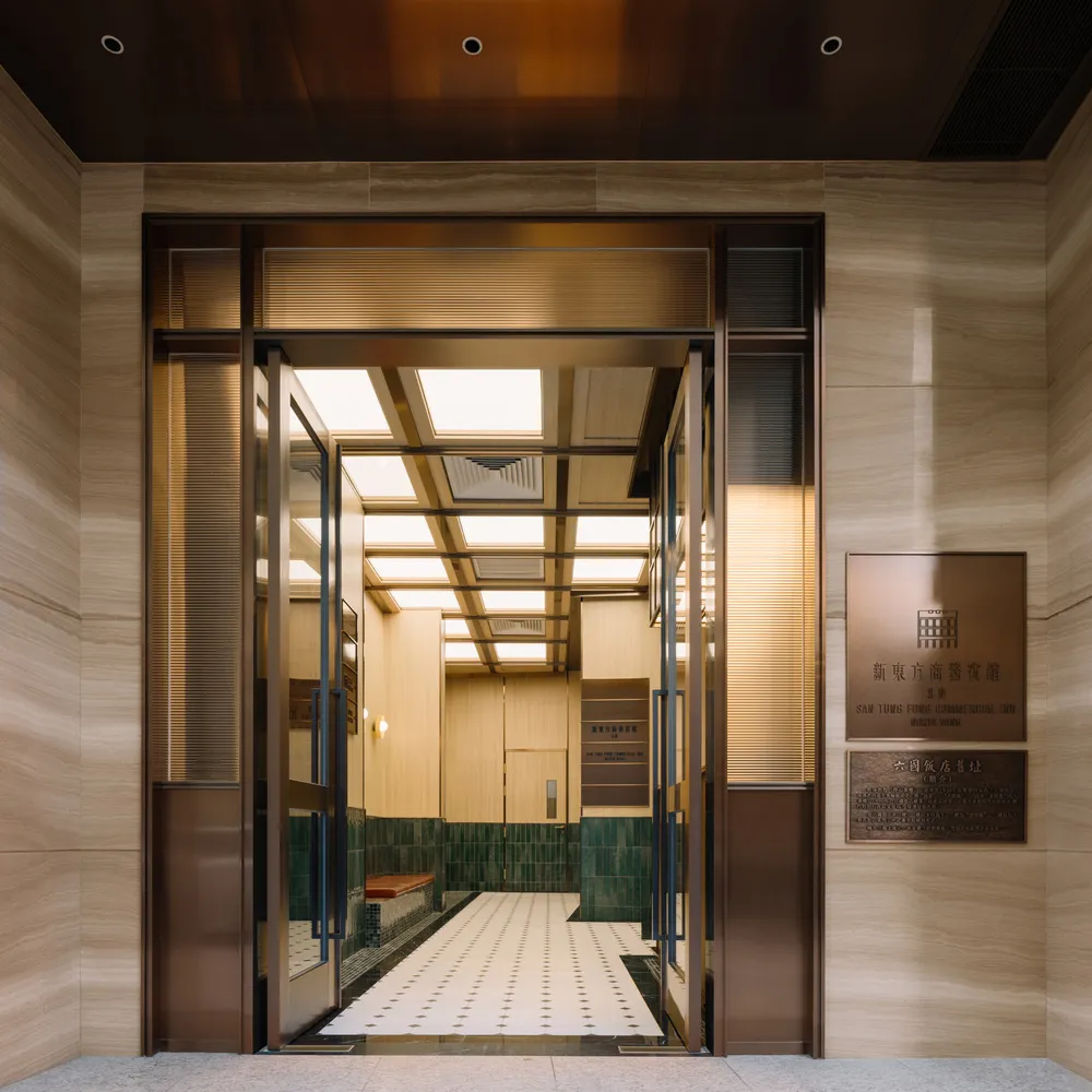Modern entrance lobby with metal, glass, and tiled flooring.