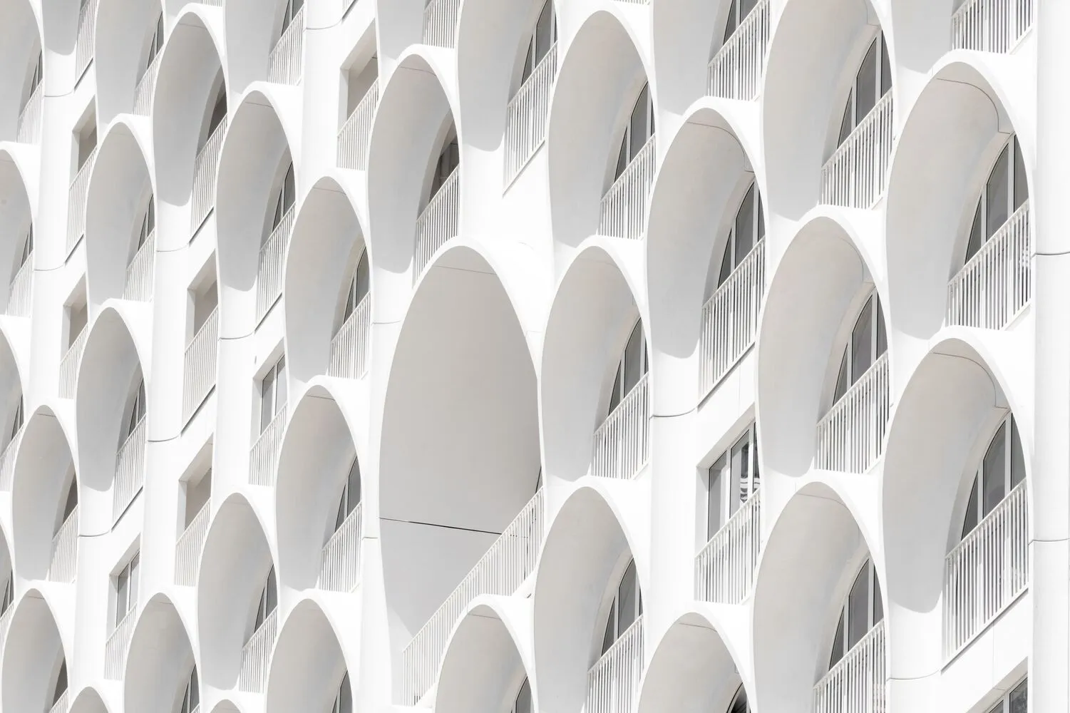 Modern facade featuring repeated circular arches in stucco exterior