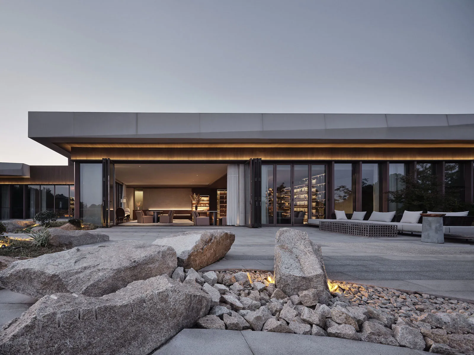 A modern residential lobby with large glass doors and stone accents.