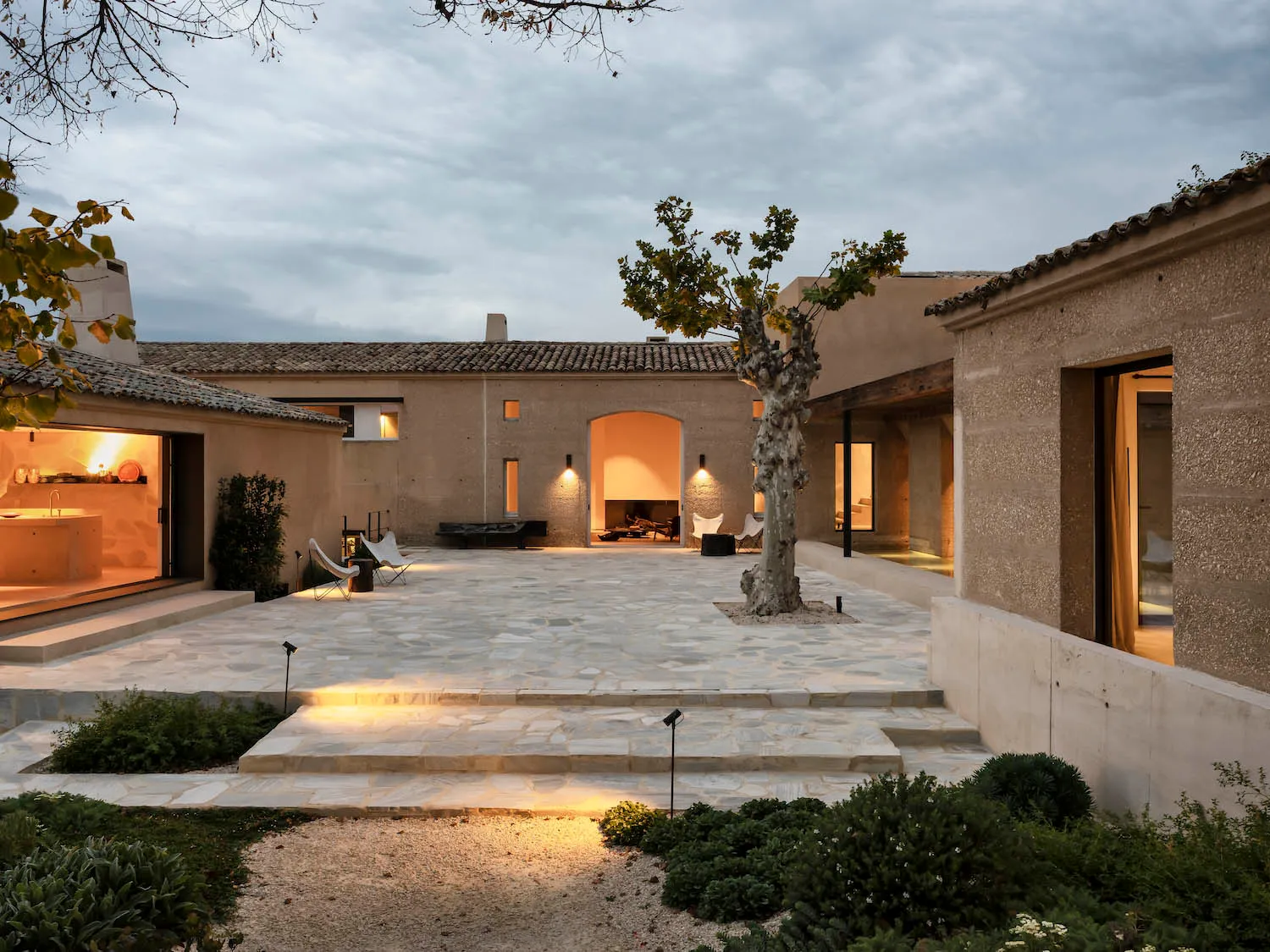 A modern residential exterior featuring concrete tiles with a warm, inviting atmosphere.