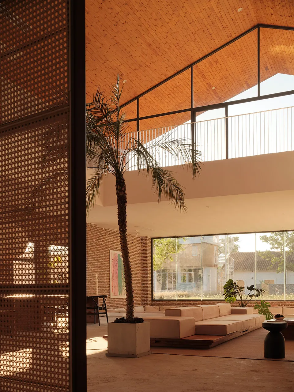 A spacious, modern living room designed with brick and concrete materials.
