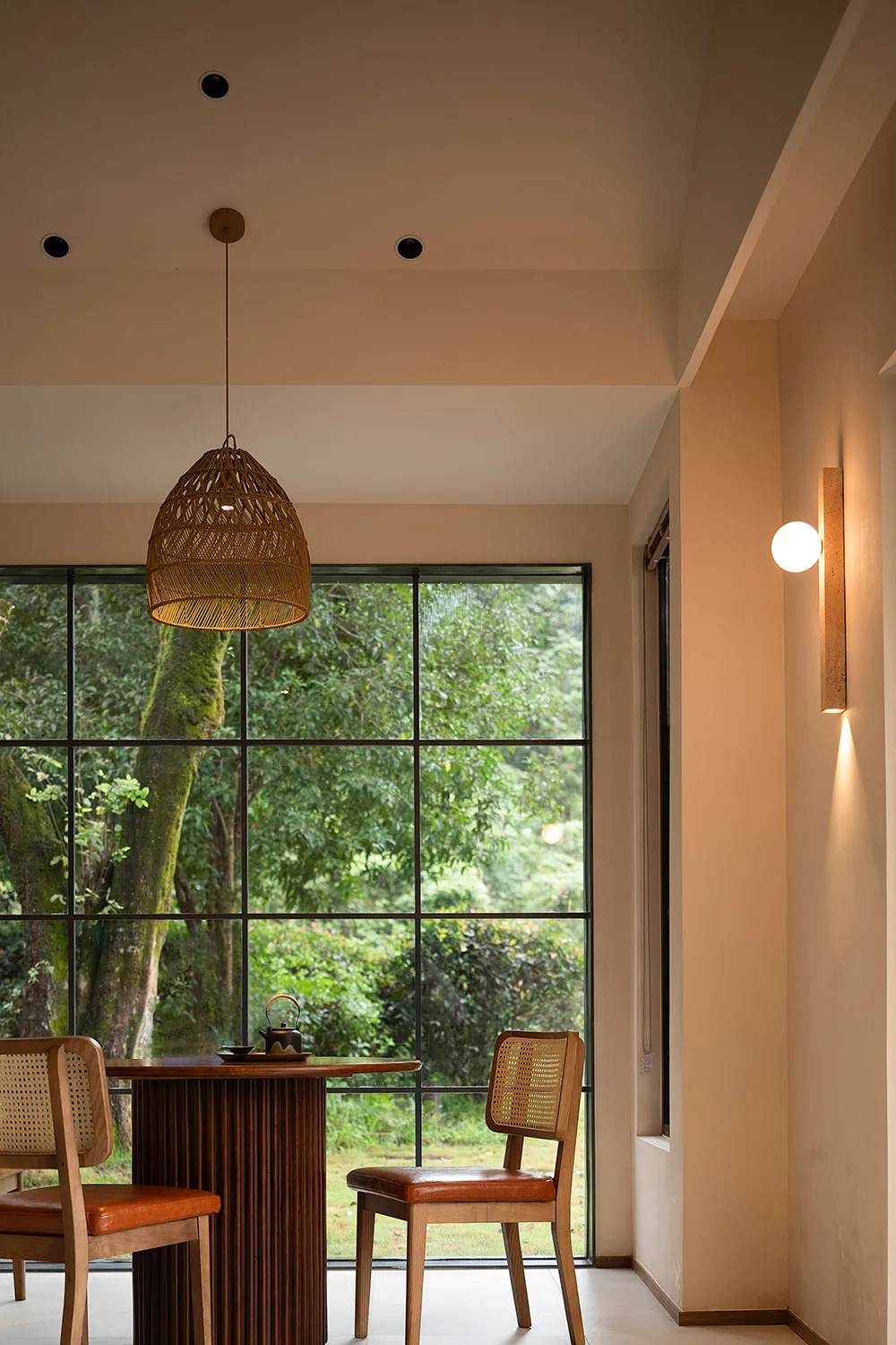 A cozy minimalist meditation room with a wooden floor, natural lighting, and a serene outdoor view.
