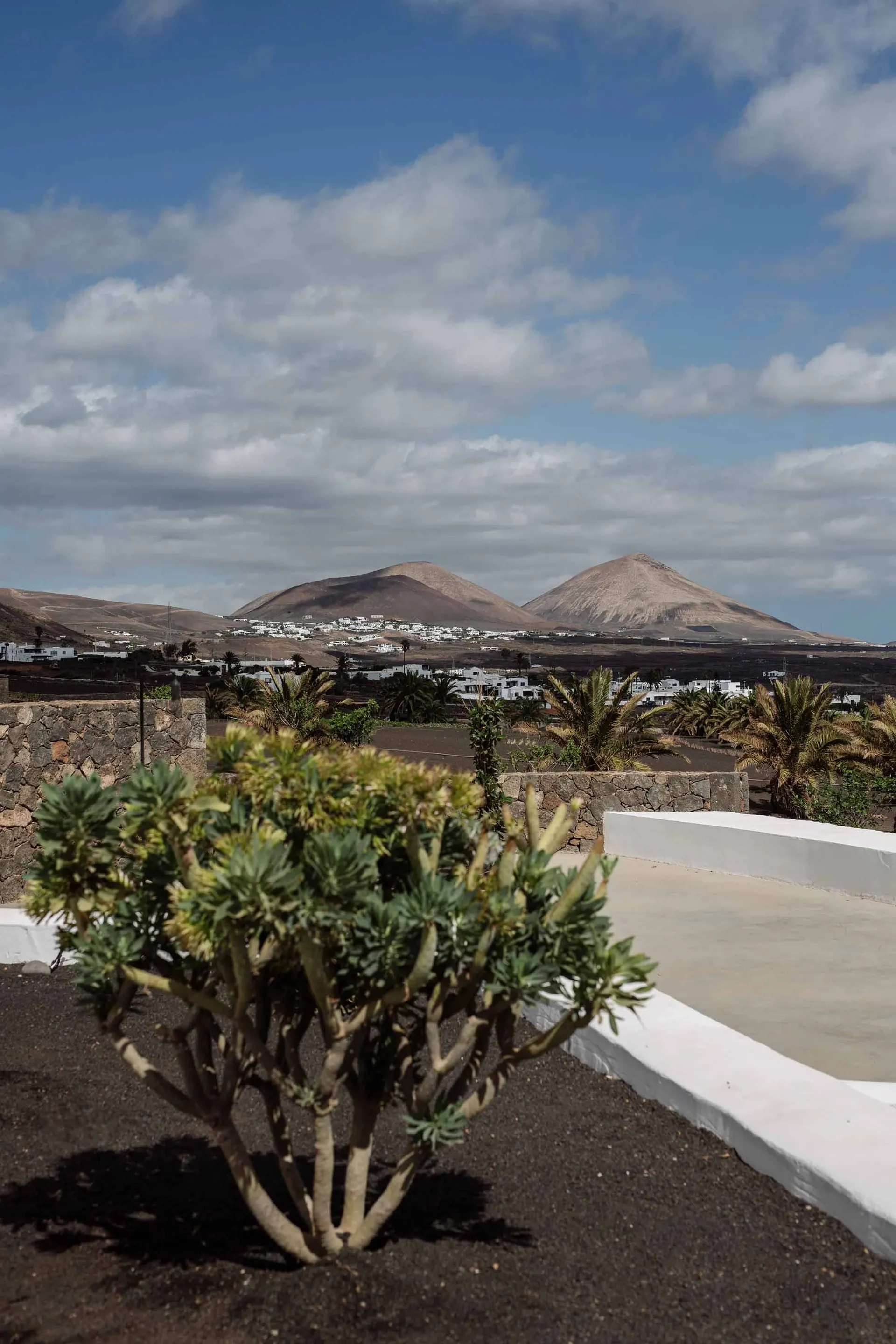 Landscape with sandy ground and construction features, including mountains in the distance.