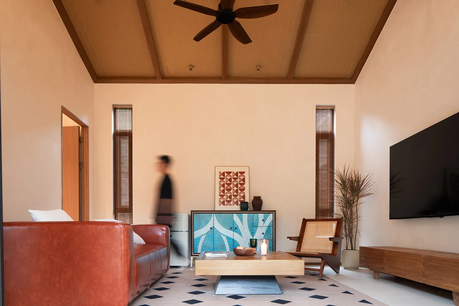 A mid-century modern living room with wooden furniture, a leather sofa, and ceramic accents.