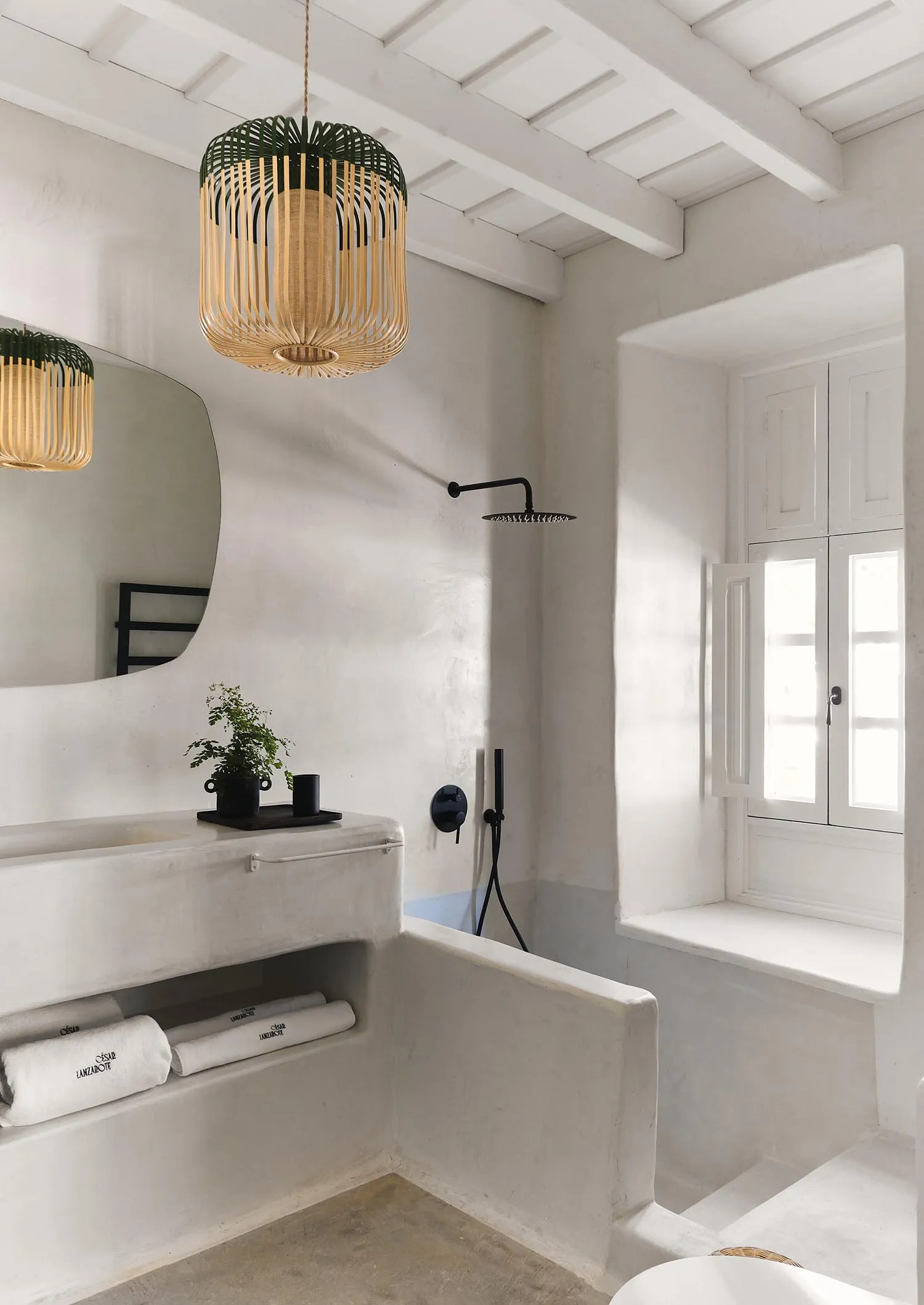 Modern minimalist bathroom with concrete finish walls and black fixtures.