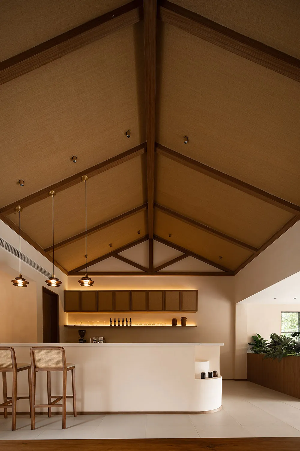 A minimalist bar counter space featuring a wooden counter, cabinets, and modern lighting.