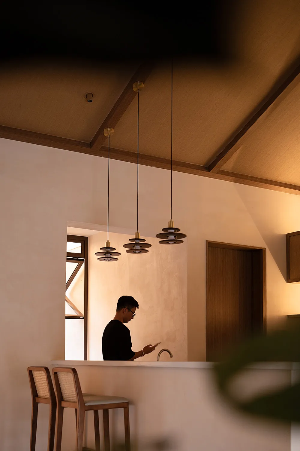 A minimalist residential interior featuring concrete walls and wooden furniture.