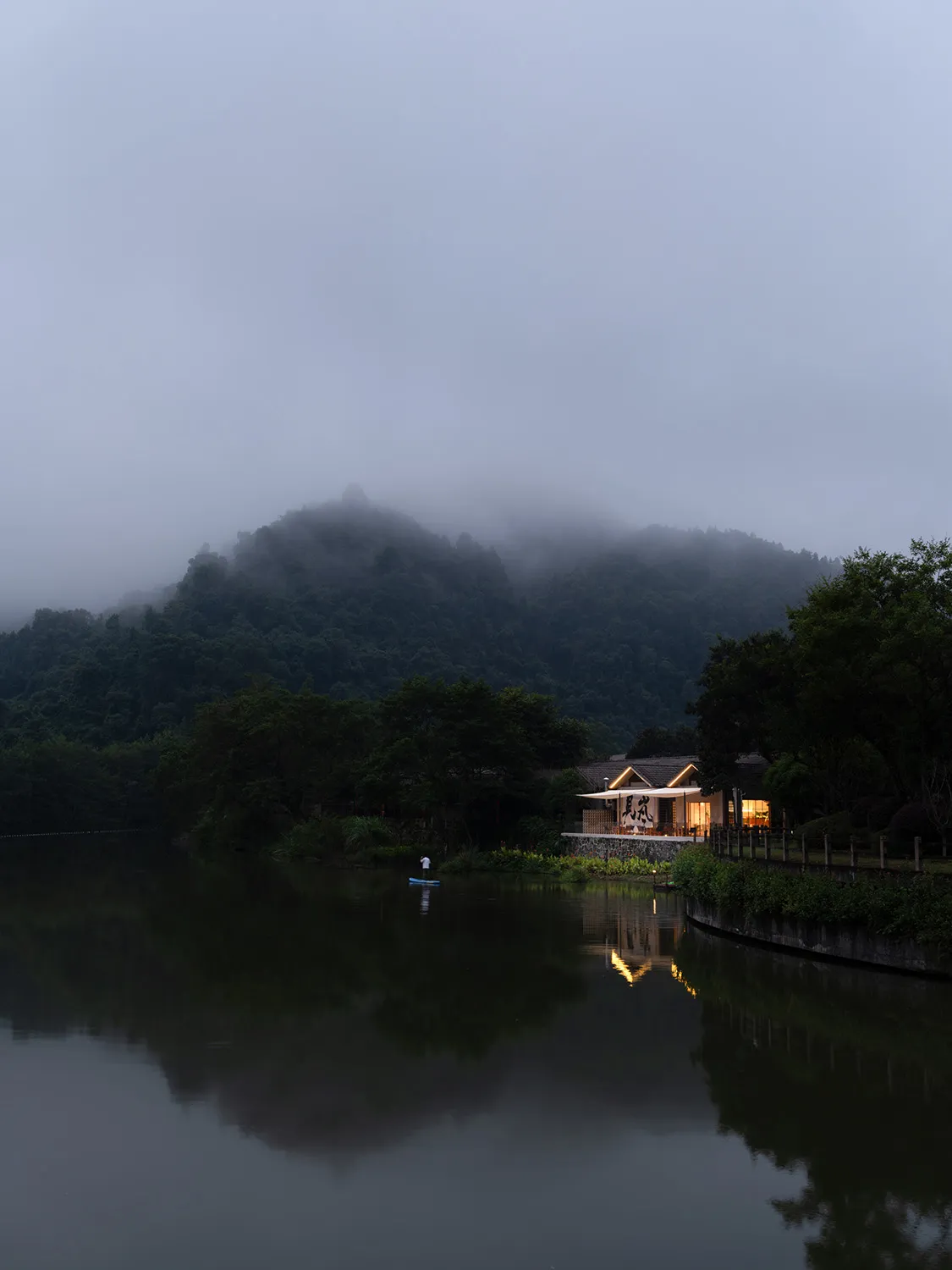 Minimalist architecture near a serene lake with natural surroundings.