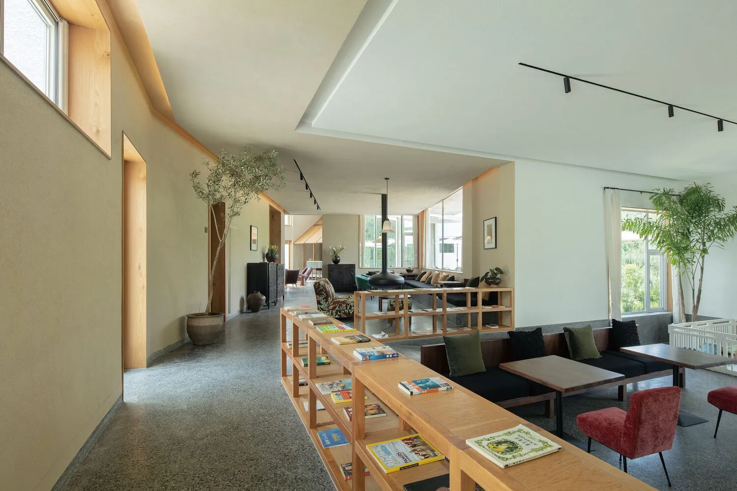 A modern living room with concrete walls and a large window.