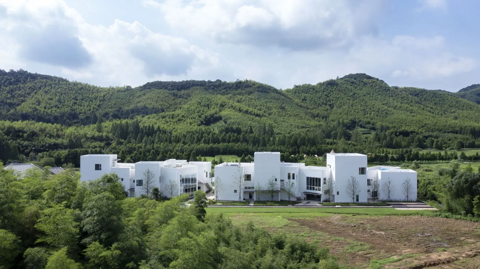 Modern residential building with white concrete exterior and geometric design.