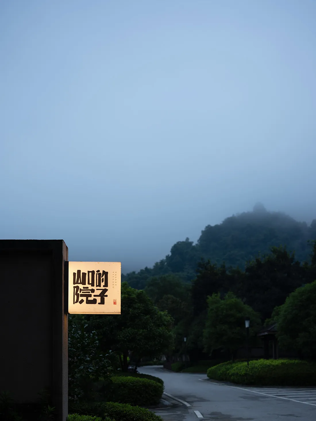 A serene night scene featuring a mountain landscape and illuminated signage.